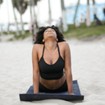 Black Woman Doing Yoga On The Beach
