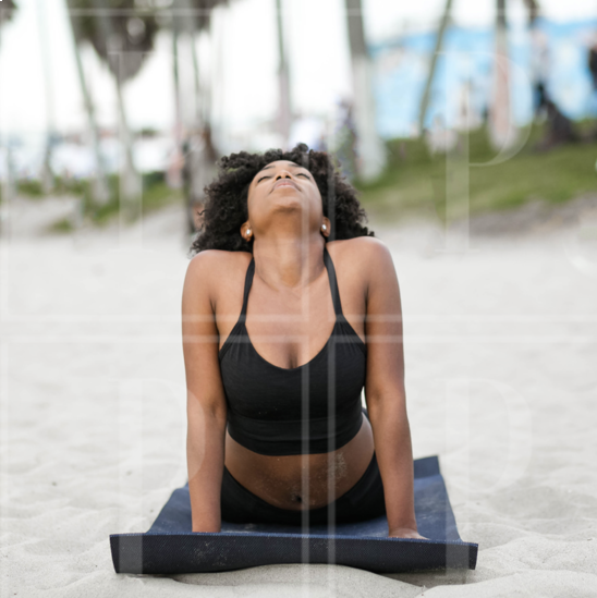 Black Woman Doing Yoga On The Beach